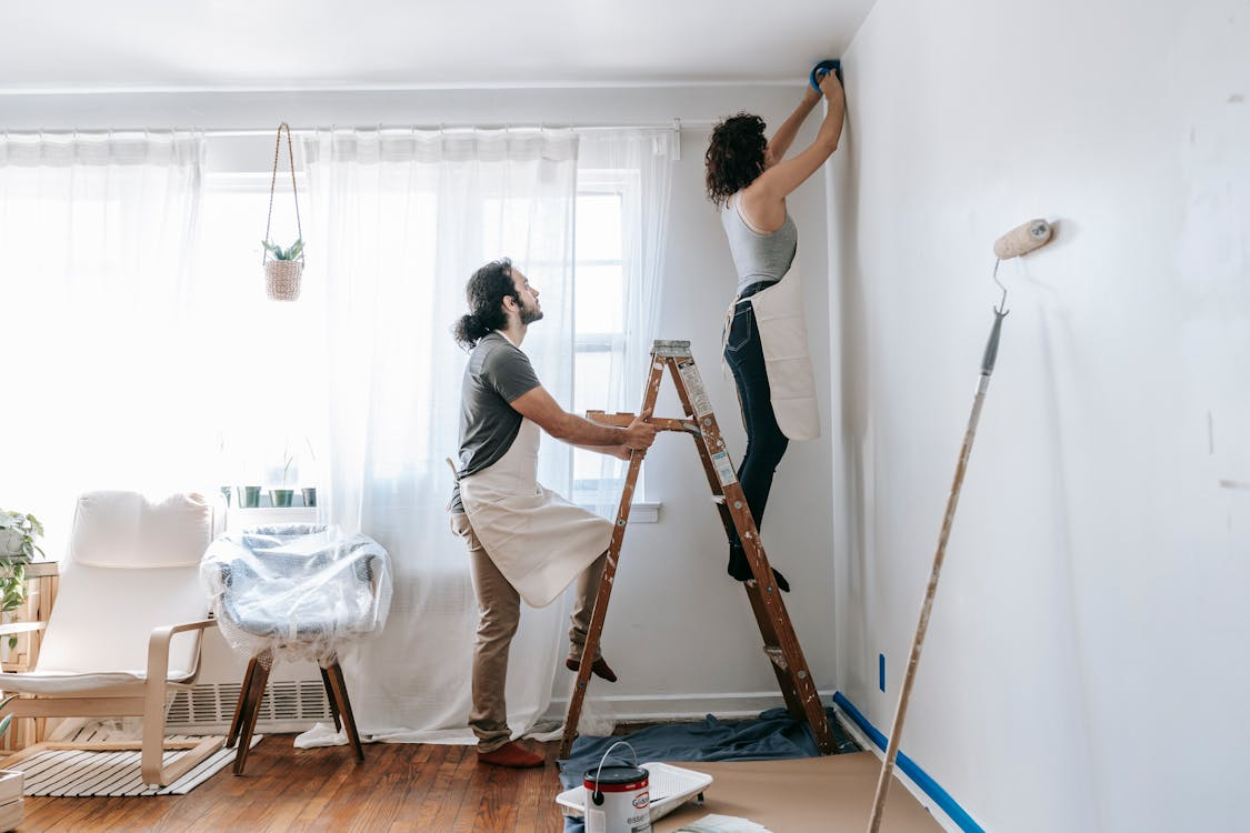 Two individuals proactively working on their house